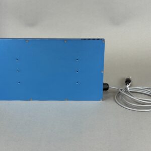 Blue metal equipment enclosure with multiple screws and a coiled gray cable on the right side near the base of the box.