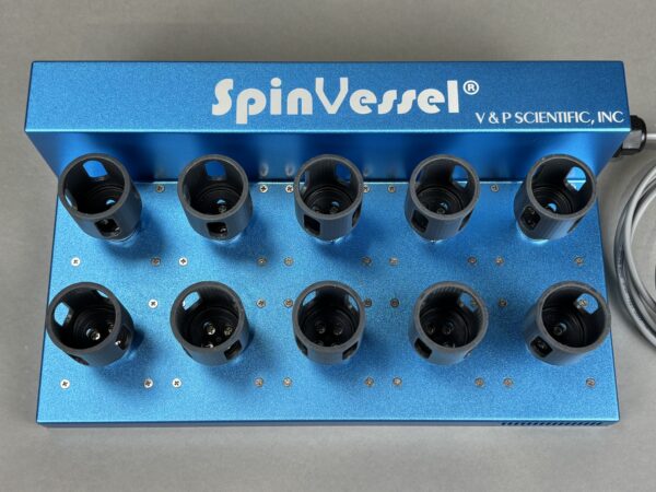 Blue lab rack with multiple black circular tube holders mounted on a metallic blue surface, branded SpinVessel by V&P Scientific, Inc.
